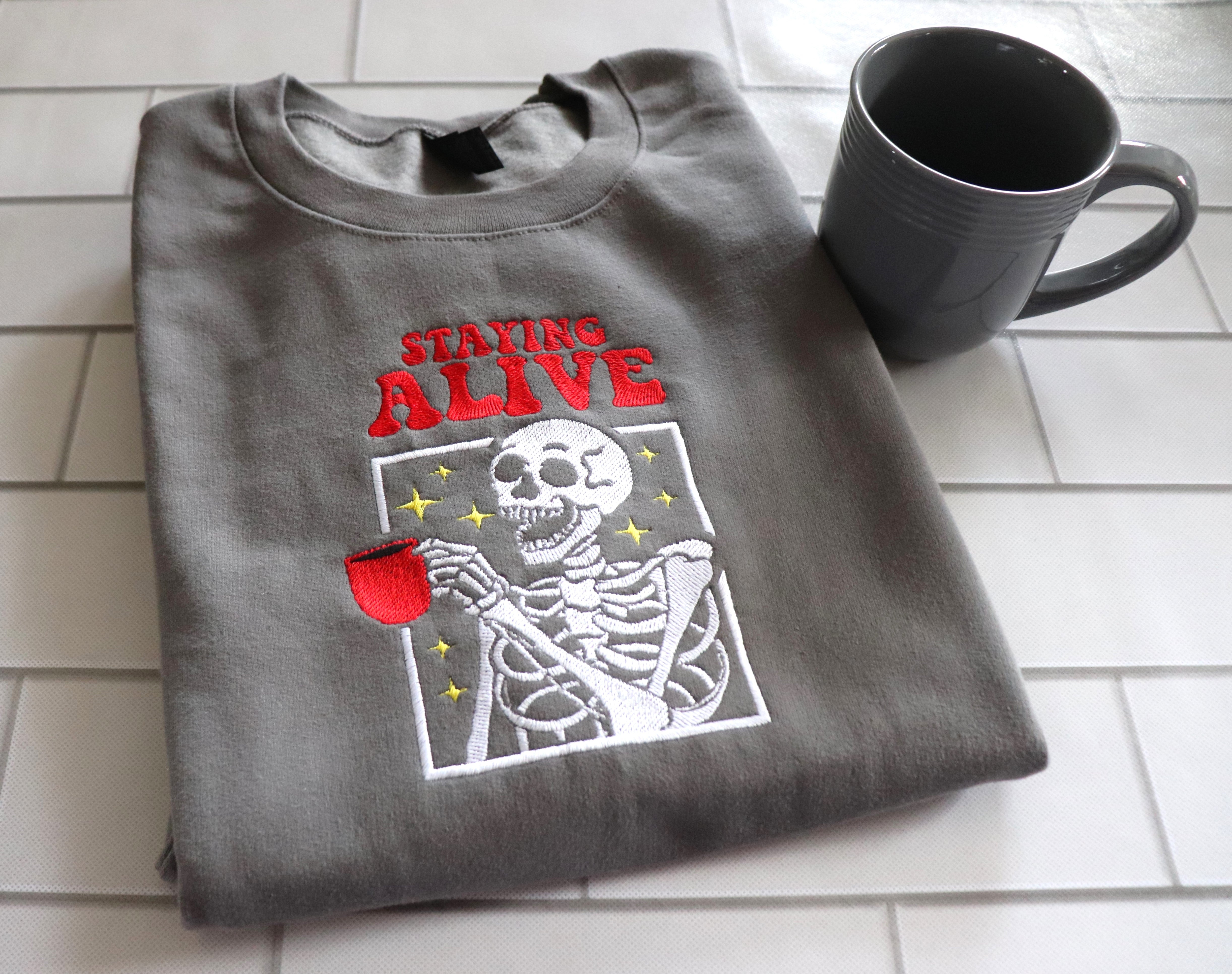 EMBROIDERED SWEATSHIRT- STAYING ALIVE COFFEE AND SKELETON